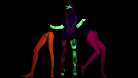 4k fantastic video of sexy cyber raver woman filmed in fluorescent clothing under UV black light. the woman has 2 extra mysterious legs.