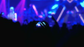 fan taking video of live rock concert, making video with cell phone, filming open air performance at smartphone