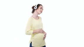 Young smiling pregnant with headphones relaxing while listening to music isolated over white
