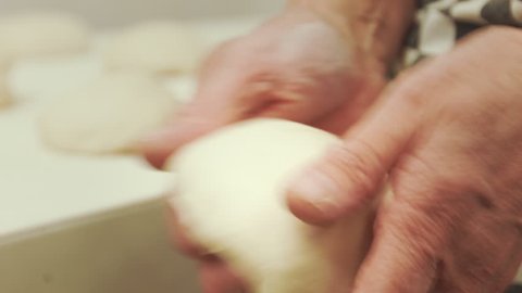 baker making dough balls with her hands close-up shot