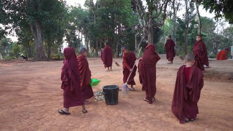 KALAW, MYANMAR - CIRCA APRIL 2017 Young monks sweep the yard