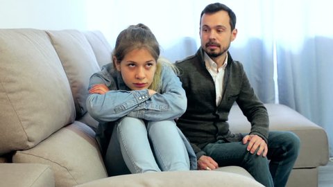 Young father having disagreement with daughter teenager at home
