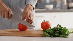 Close up footage of female's hands accurately slicing tomatoes to make salad in slowmotion