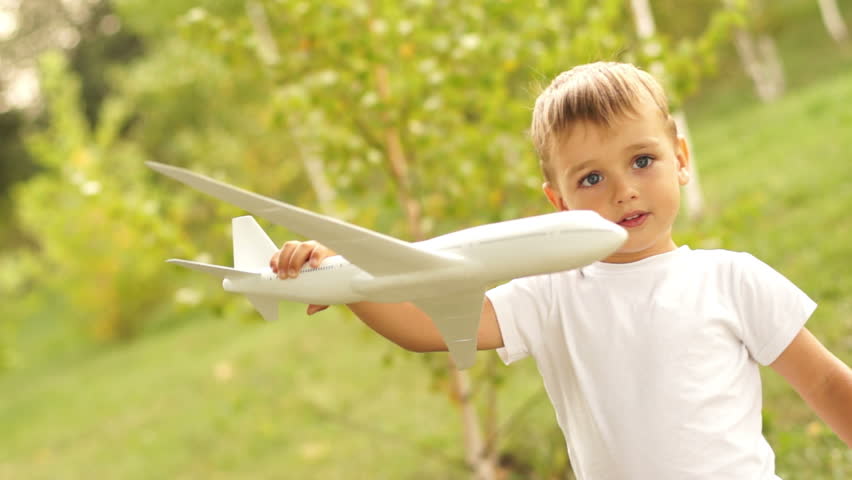 Little boy with toy airplane outdoors
