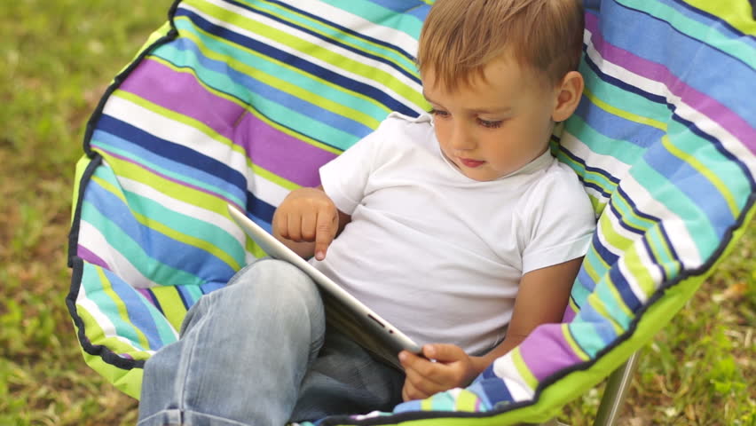 Boy with touchscreen outdoors
