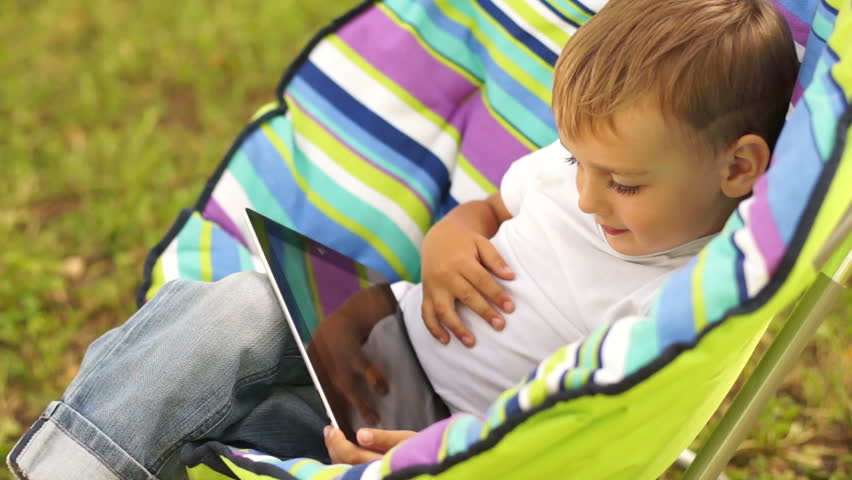 Smiling boy with touch pad outdoors
