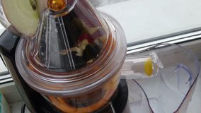 Juicer squeeze apples near window, hand open cover and juice pour in glass close up, mobile phone video.