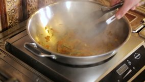 Chef Mixes vegetable Pasta in pan