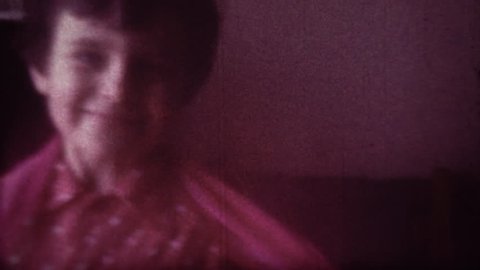 Family chronicle: Little girl child is dancing at home. Her father is recording video on 8 mm retro camera.