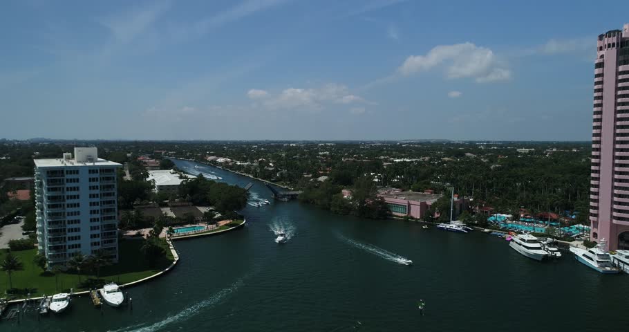 Aerial orbit around a powerboat crossing Boca Raton water with waterfront condominiums in the background, 2017.