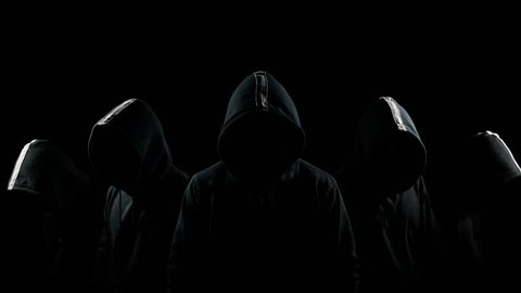 Five mysterious hooded men standing in the dark hoodies and hidden faces