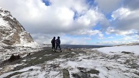 Magnificent snow-covered rocks on a sunny day and nature walkers. Slow Motion Footage.