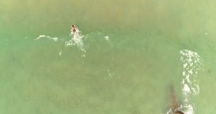 Aerial drone footage of surfer fallen from the wave and ocean waves reaching shore. Drone follows the wave smoothly. Phuket.Thailand 2017.