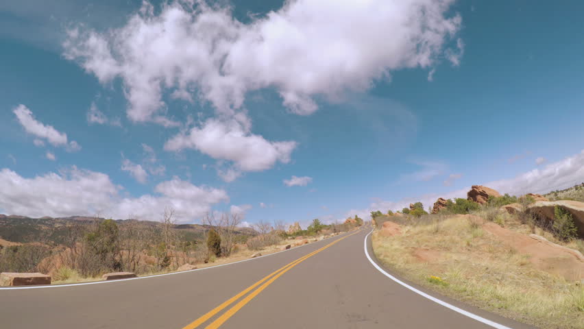POV point of view - Driving through the park with large red sanstone formations.