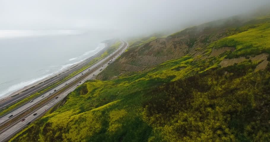 flying along flower covered mountains, ocean, highway 101