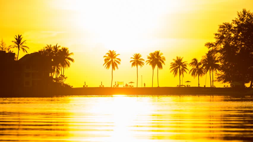 4K Timelapse of beautiful summer vacation sunset tropical beach paradise with palm tree silhouette and golden sky.  Royalty-Free Stock Footage #26072057