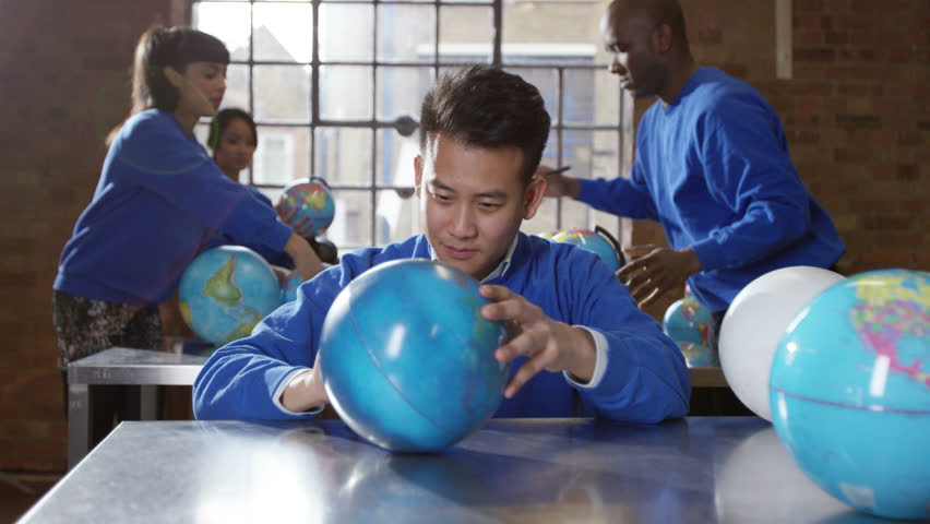 4K Team of workers checking &amp; finishing products in globe production factory