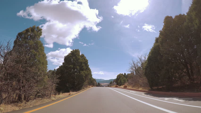 POV point of view - Driving through the park with large red sandtone formations.