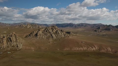 Park Terelj rocks and steppe near Ulaanbaatar Mongolia. Summer autumn sunny blue sky clouds. Beautiful Mongolian nature. Aerial helicopter fast forward flight above the mountains flight 