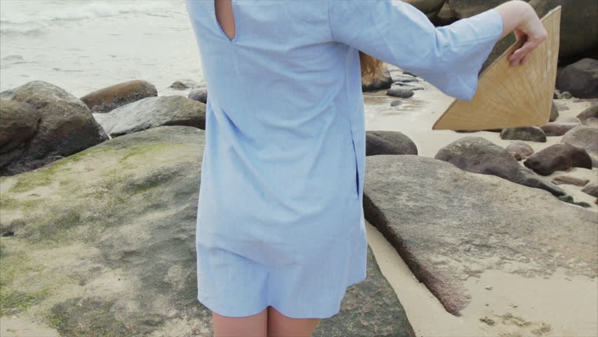 A girl in a blue dress puts on a Vietnamese hat. A man approaches a girl and a pair of lovers embrace