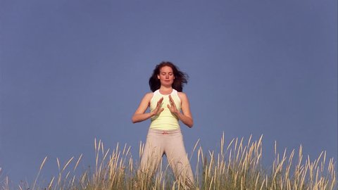 A woman doing qi gong by the sea