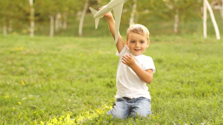 Future aircraft pilot playing with toy airplane outdoors
