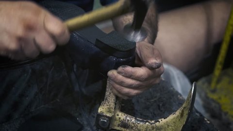 Shoemaker repair old shoes in his workshop