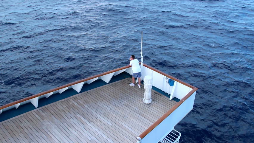 A cruise ship passenger looks out at sea.