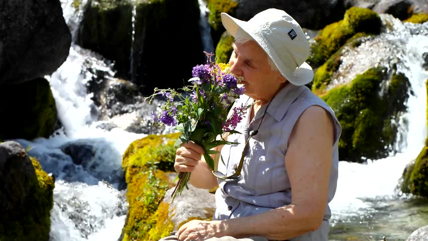 Woman with flowers by the water