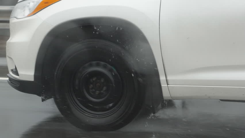 Slow motion drive. Passing vehicle. Detail of tire with droplets of water. Shot through rainy passenger window.
 Royalty-Free Stock Footage #26116457