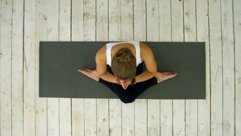 Sporty beautiful young woman practicing yoga, sitting in cross legged position