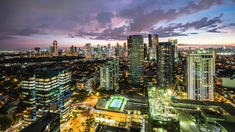 Dusk to night time lapse view looking over modern buildings in Makati City, Metro Manila, Philippines.