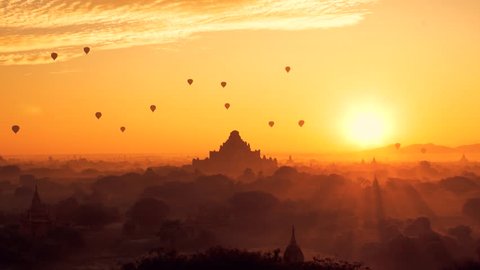 Scenic sunrise with many hot air balloons above Bagan in Myanmar. Bagan is an ancient city with thousands of historic buddhist temples and stupas.