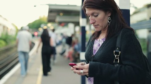 Young woman using smartphone on train station
