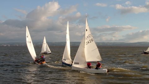 WIRRAL, CHESHIRE/ENGLAND - JUNE 12: Sailing dinghies on West Kirby Marine Lake race past a buoy on June 28, 2012 in Wirral. The Marine Lake is a man made coastal lake fed by the sea at high tide.