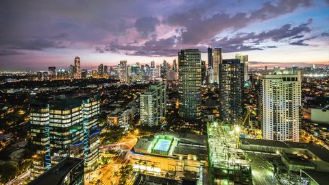 Metro Manila time lapse, looking over Makati city skyline at sunset, Philippines - zoom in. 