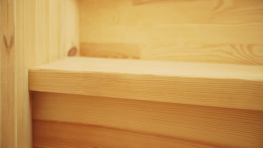 Hands of man polishing wooden steps of staircase boards sandpaper for painting