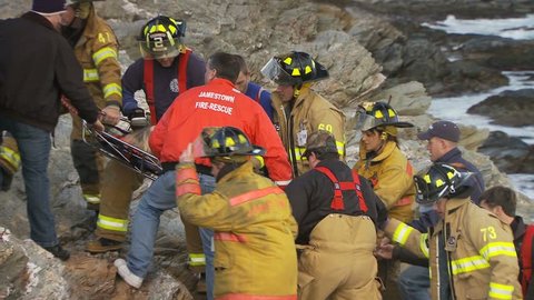 JAMESTOWN, RHODE ISLAND - CIRCA NOVEMBER 2010: Rescue crews carrying stretcher with woman on rocky shore - closeup Editorial Stock Video