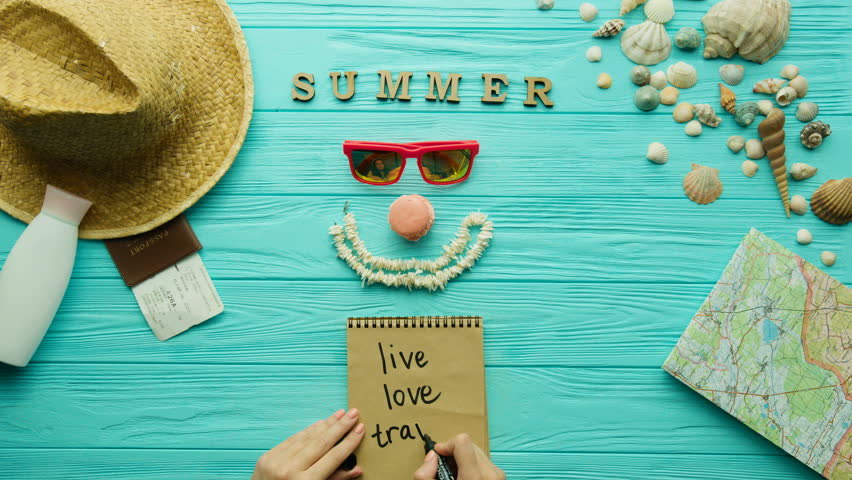 Young woman wriiting on here notebook. Trip mood. Top view. Turquoise background.