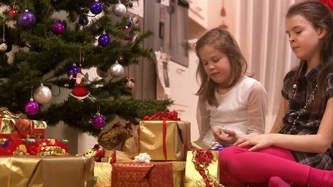 Girls sitting by the Christmas tree Stock Video