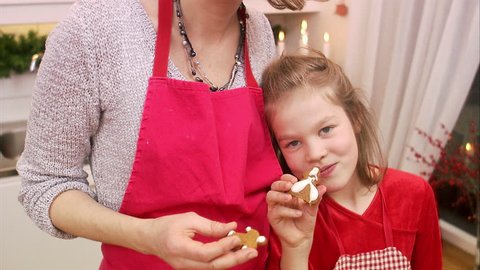 Mother and daughter eating gingerbread biscuits Stock Video
