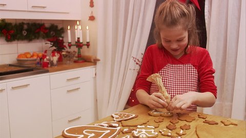 a young girl decorating gingerbread biscuits Stock Video