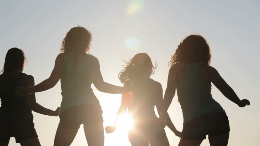 Team of four dancers dancing over sun together