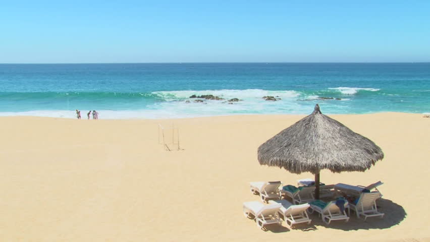 Unrecognizable people enjoy perfect blue sky day at the beach in Cabo San Lucas,