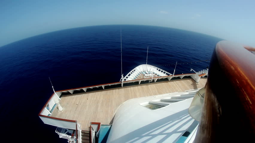 Looking out the front of a large cruise ship in the ocean.