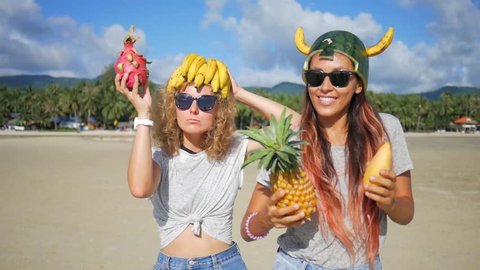 Two Carefree Young Girls Fooling on the Beach and Dancing with Exotic Thai Fruits. Vegan Dance. Phangan, Thailand. HD Slowmotion.