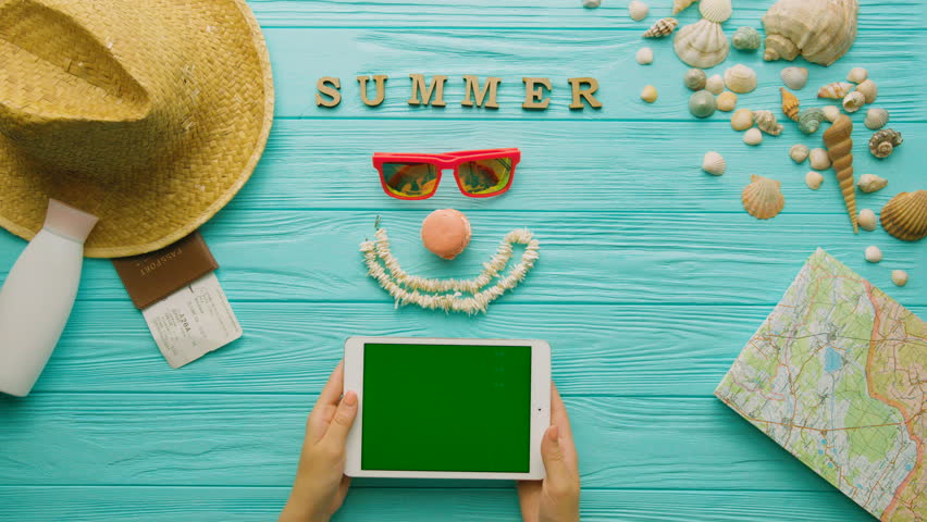 Young woman hands using tablet on table. Top view. Chroma key, Green screen. Trip love. Turquoise background.