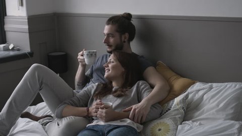 Young couple having coffee in bed