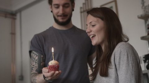 Boyfriend giving girlfriend a birthday cupcake
