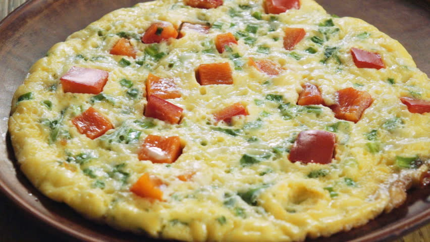 SLOW MOTION: scrambled eggs are laid out from a frying pan on a plate, 240 fps.